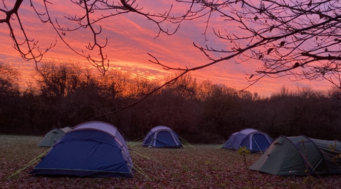Scout hike tents at dawn with red sky