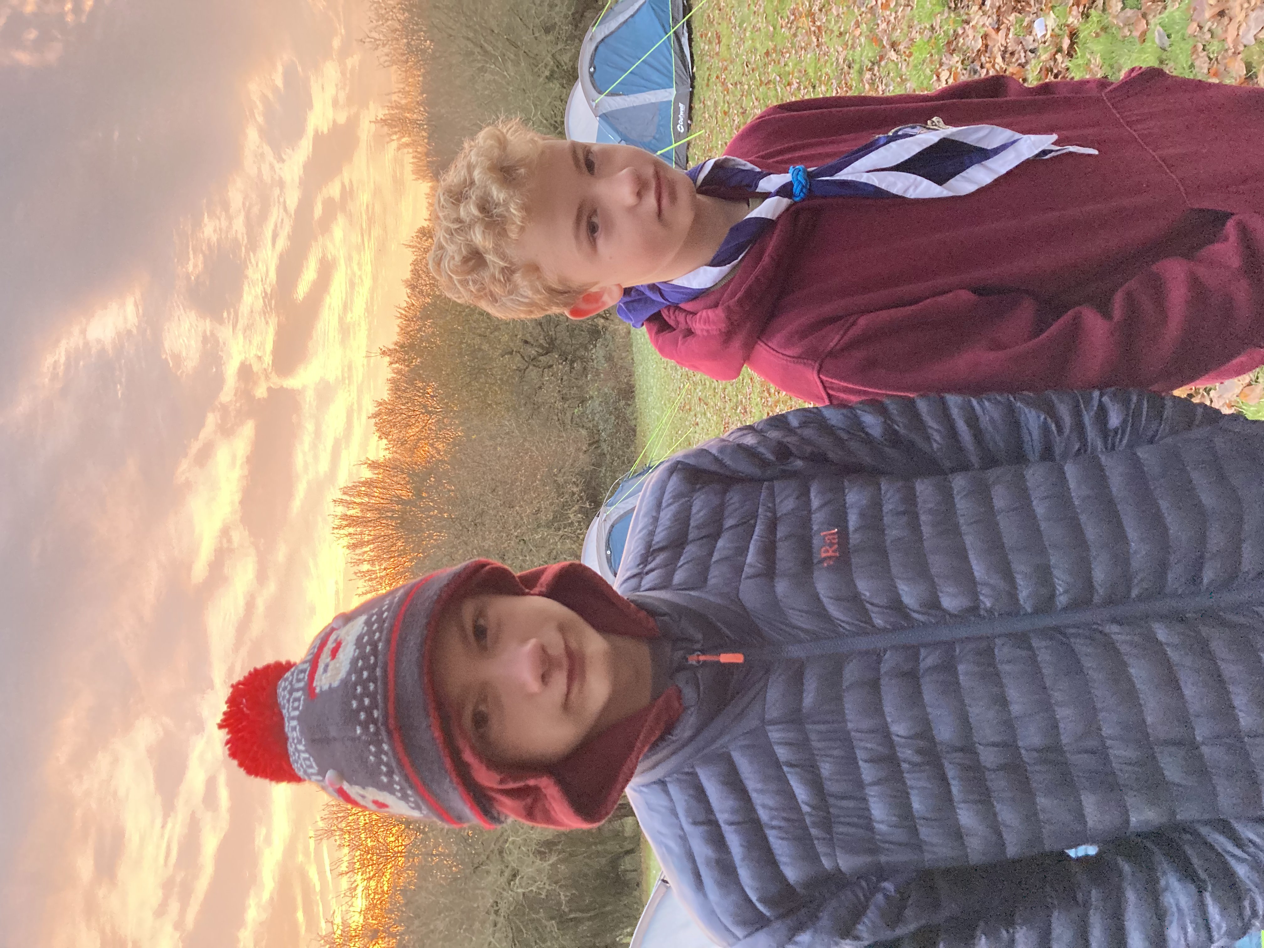 Chilly scouts at dawn with red sunrise and tents in the background